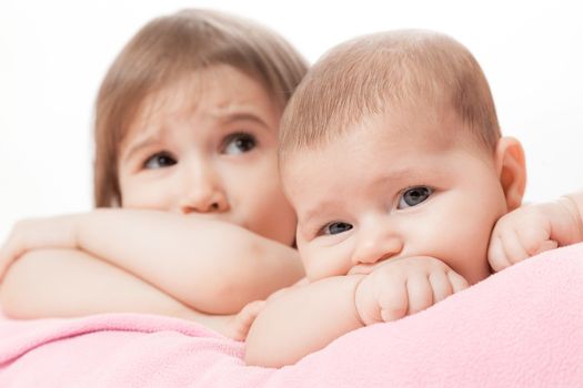 two little girls of the sisters lie on a pink plaid