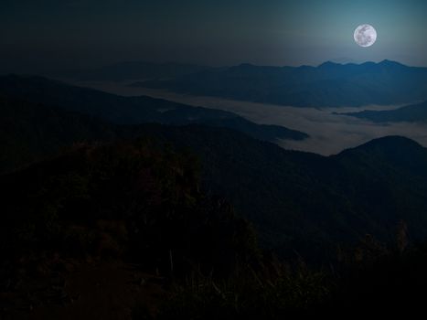 Mountain and mist with full moon at midnight.
