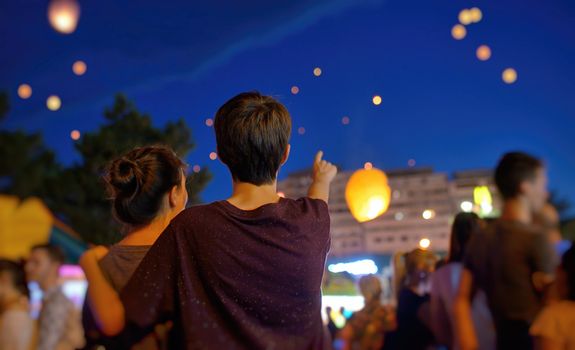 Teens in summer night with watching paper lantern