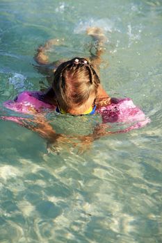 Little girl dives in the clear sea