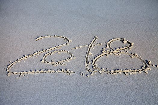 New year 2018 written on sand