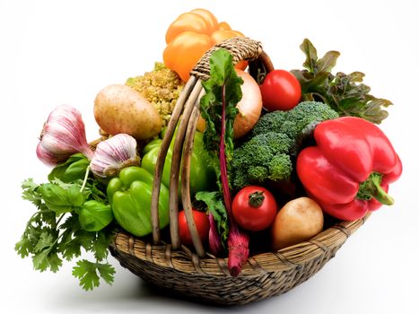 Fresh Vegetables Basket with Bell Peppers, Greens, Tomatoes, Potatoes, Garlic, Onion, Young Beet, Broccoli and Romanesco Cauliflower closeup on White background