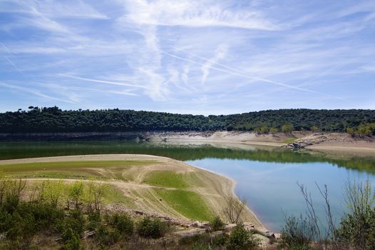 Embalse de Ricobayo with Reflection of Green Trees against Cloudy Sky in Sunny Day Outdoors. Zamora, Castilla and Leon, Spain