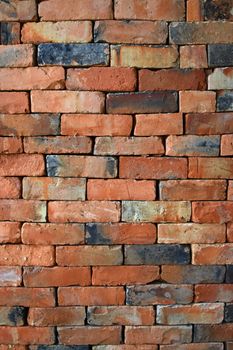 Rough red brown brick wall background texture without cement close up, side view