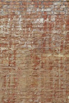 Old weathered aged rough brown brick wall background texture with white and red paint stains and runs, close up, side view