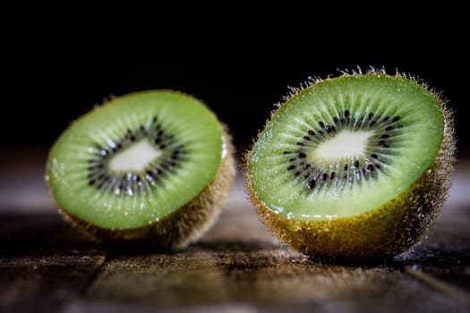 Kiwi in the old kitchen on a wooden table. Black background.
