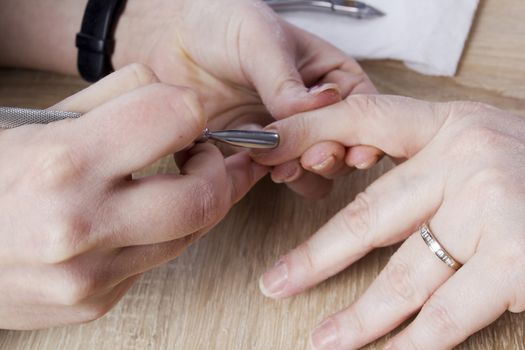 Professional manicure procedure in beauty salon. Hands close up.