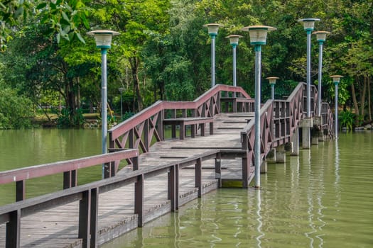 walkway wooden bridge over pond on park of silpakorn university, Nakhonpathom