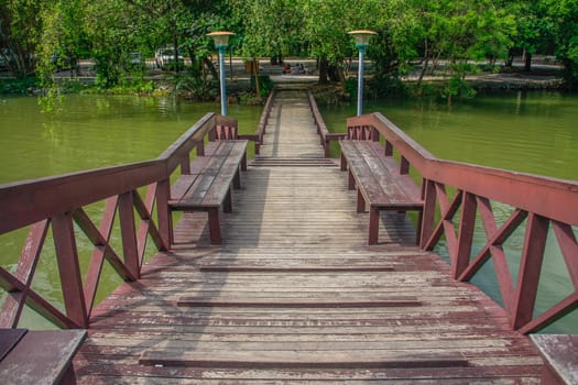 walkway wooden bridge over pond on park of silpakorn university, Nakhonpathom