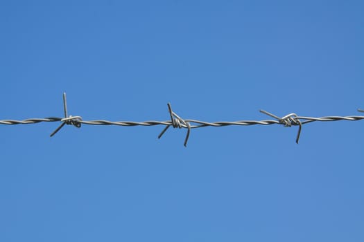 barbed fence with blue sky