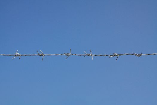 barbed fence with blue sky