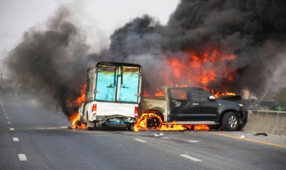 small truck with pickup car crash center street, be fire and smoke very thick, blur