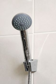 head shower hanging in tile wall of bathroom