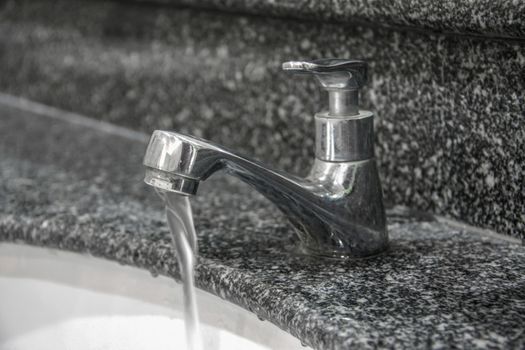 modern style faucet on granite tile with water drop in basin, wash hand
