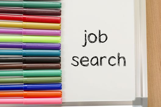 Felt-tip pen and whiteboard on a wooden background and job search text concept