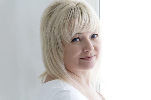 horizontal portrait of blond woman with blue eyes in white