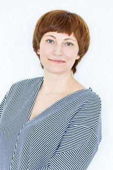 Portrait of happy woman with short brown hair near white wall