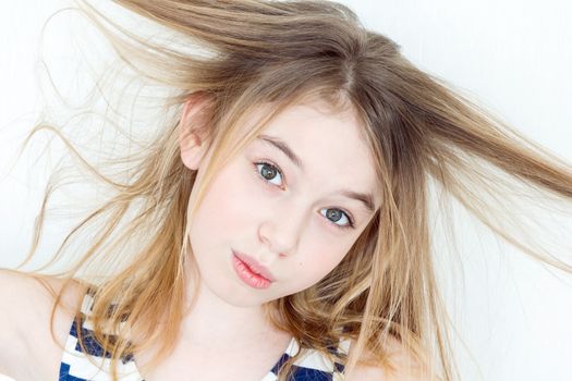 Portrait of girl eleven years old with big eyes playing with long hair