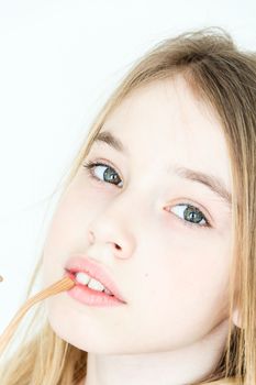 Cute girl eleven years old with blond long hair and green eyes on white