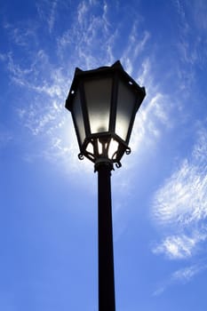 Lamppost in backlight on blue sky