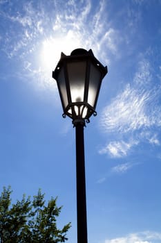 Lamppost in backlight on the blue sky