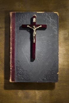 Ancient book and crucifix on a wooden table
