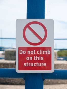 a red and white sign saying do not climb on this structure