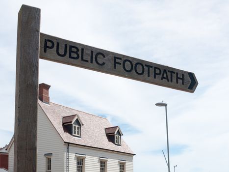 wooden post in town saying public footpath