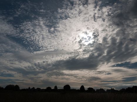dramatic grey moody and very cloudy messy sky over a field outside