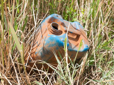 a discarded and rusted oil tank in the reeds