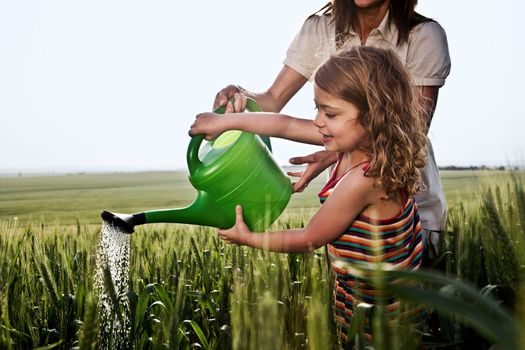 Woman and child with watering can
