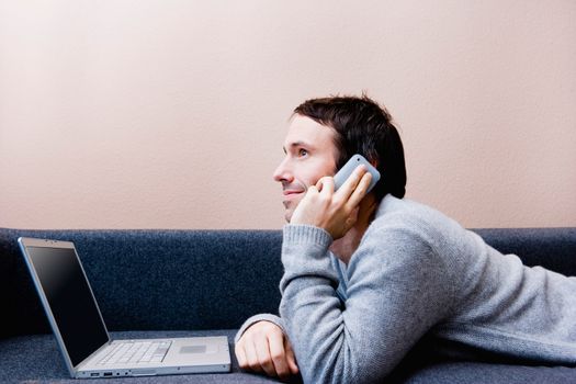 Man laying with laptop on couch