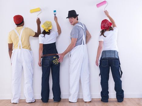 Group of friends about to paint wall.