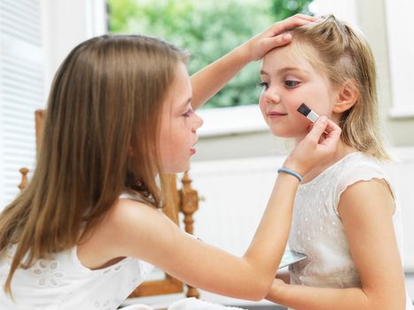 Girl putting make-up on friend