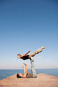 Couple Playing Air Plain On Pier