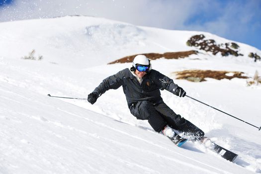 Man in black suit carving off piste.