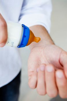 Man testing temperature of baby bottle