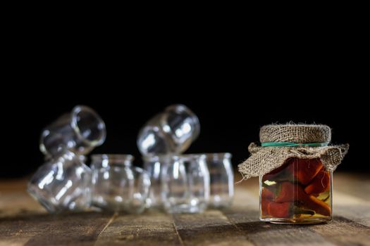 Mortar on a wooden table and empty jars, black background