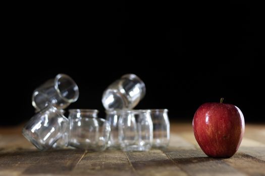 Mortar on a wooden table and empty jars, black background