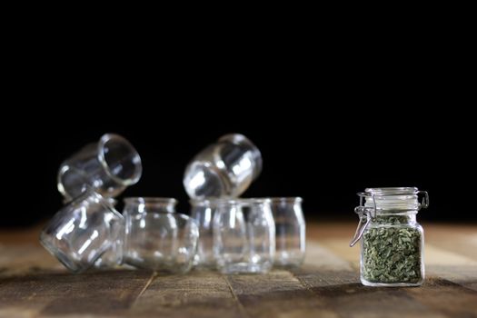 Mortar on a wooden table and empty jars, black background