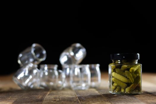 Mortar on a wooden table and empty jars, black background