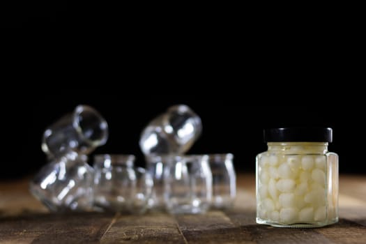 Mortar on a wooden table and empty jars, black background