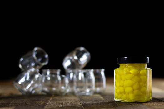 Mortar on a wooden table and empty jars, black background