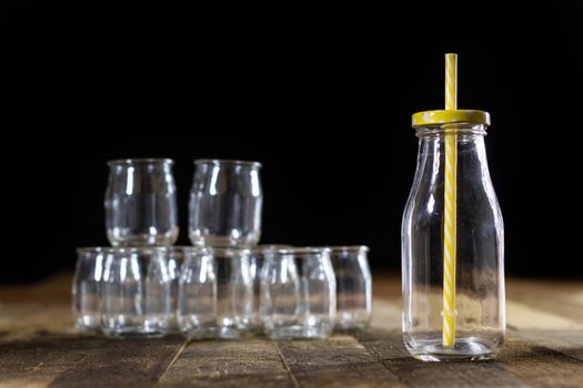 Glass empty containers on a wooden table. Jars, bottle. Black background