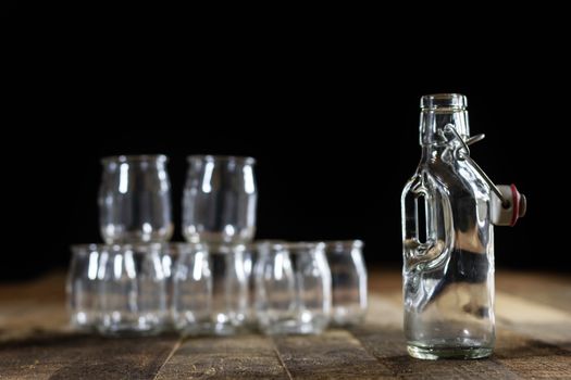 Glass empty containers on a wooden table. Jars, bottle. Black background