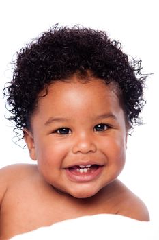 Happy smiling cute adorable teething baby face showing milk teeth, with curly hair.