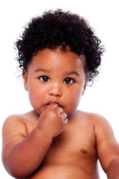 Cute adorable beautiful baby toddler face with hand in mouth and innocent expression and curly hair.