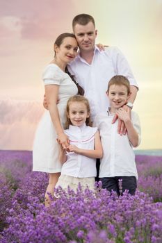 Family of four among lavender field at sunset