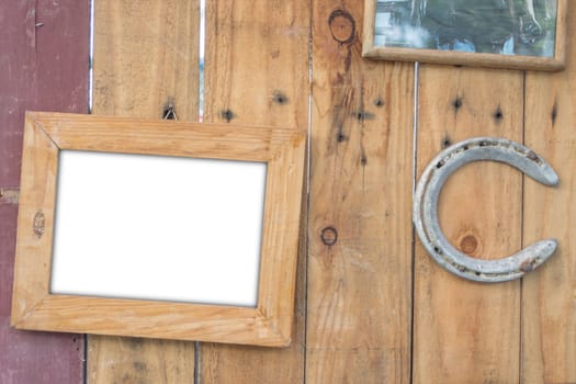 old vintage wooden photo frame and old rusty horseshoe on vintage wooden board