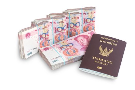 Yuan banknotes from China's currency and thailand passport ready to travel . Chinese banknotes isolated on white background.